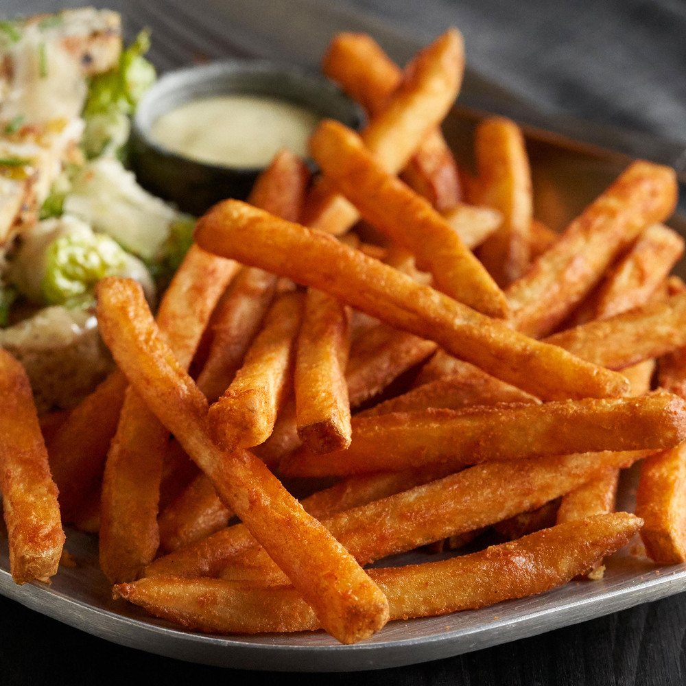 A plate with golden french fries or fried potatoes